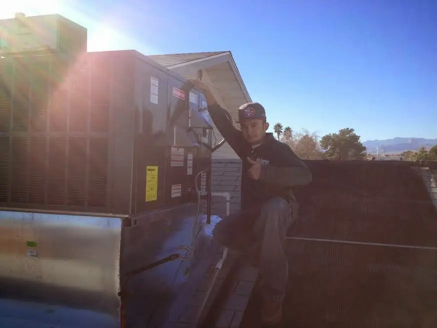 HVAC technician performing HVAC Inspection on a rooftop unit in Le Roy